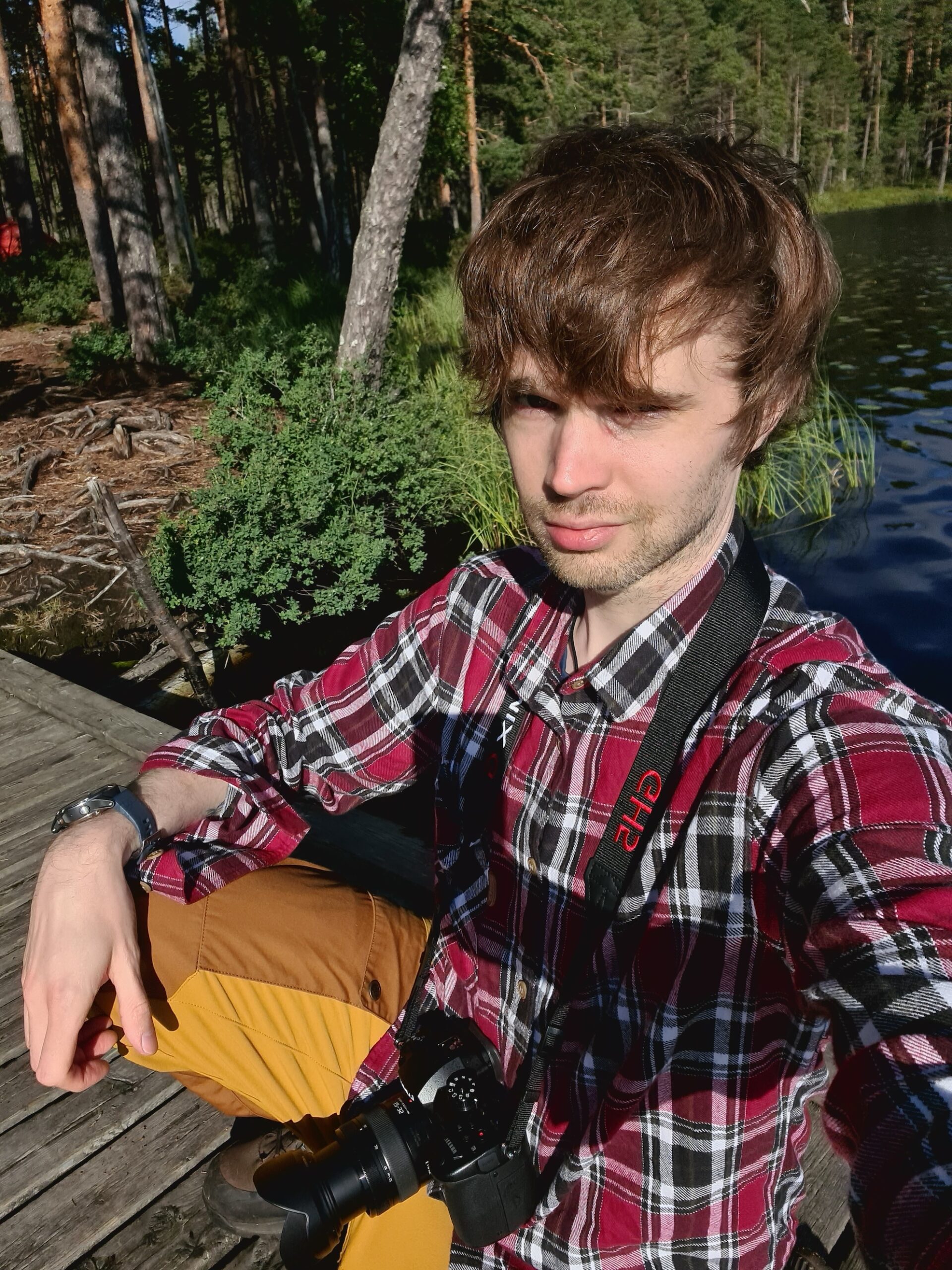 Tuomas, ratkaisukeskeinen lyhytterapeutti, istuu laiturilla järven rannalla metsämaisemassa.